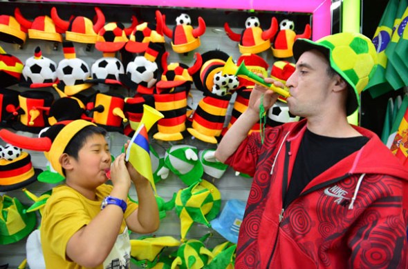 Merchants and soccer fans blow vuvuzela horns at Yiwu International Trade City in East Chinas Zhejiang province on May 6. Almost 90 percent of the horns for the Brazil World Cup are produced in Yiwu. [Lyu Bin / For China Daily]