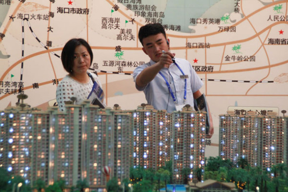 A visitor learns about a housing project at the Hainan Spring Property Exhibition held in Haikou this month. SHI YAN/CHINA DAILY