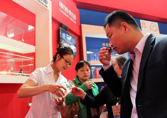Visitors taste baijiu at the 2013 Western China International Fair. A burst price bubble and changing tastes caught liquor makers by surprise. Xinhua  