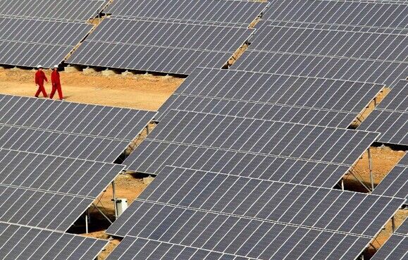 Workers patrol among the photovoltaic equipments in Hami, northwest China's Xinjiang Uygur autonomous region, March 16, 2012.[Photo/Xinhua]   