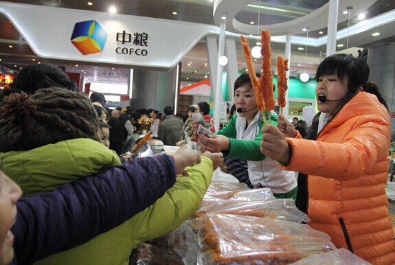 Customers buy meat at Cofco Group's booth at a food exhibition in Wuhan, Hubei province. Provided to China Daily  