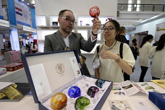 A Czech exhibitor introduces a crystal goblet to a visitor during the 2014 Central and Eastern European Countries' Products Fair (CEEC Fair) in Ningbo, east China's Zhejiang province, June 8, 2014. [Photo/Xinhua]  