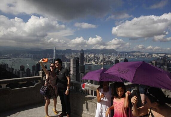 Mainland tourists at the Peak overlooking Hong Kong. Retailers in the city are feeling the pinch as the number of mainland visitors to the city continues to drop. [Photo/China Daily]  
