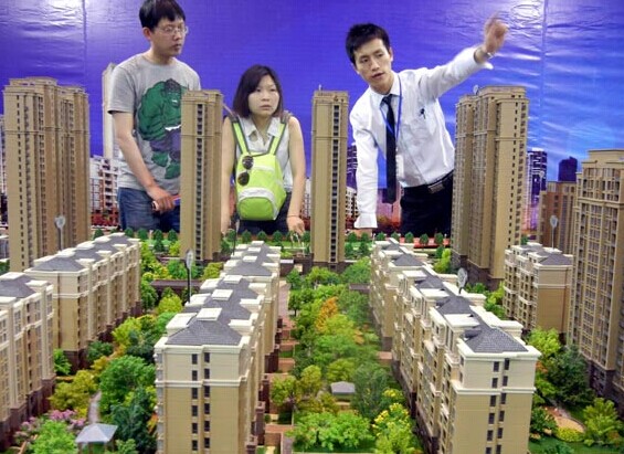 A salesman introduces a housing project to visitors at the Suzhou Property Exhibition last month. The central bank's reserve requirement ratios cut on Monday dashed the hopes of some property developers for a broad-based credit easing this month. Wang Jiankang / For China Daily