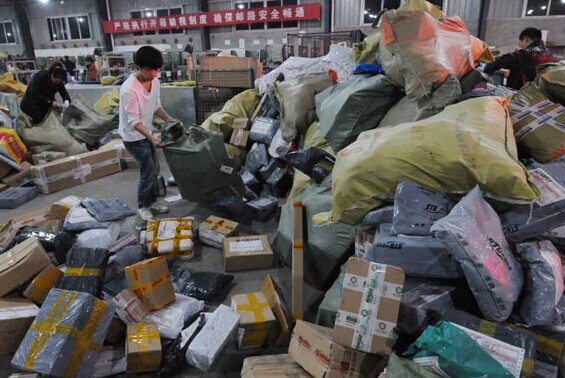Workers at a delivery service company in Jiujiang, Jiangxi province, sort packages on the ground. Hu Guolin / For China Daily