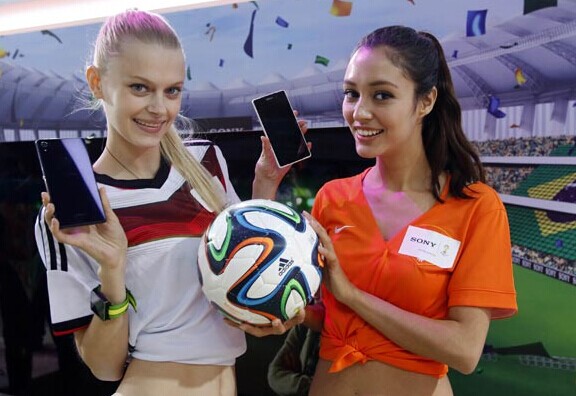 Soccer cheerleaders help promote smartphones, with apps for FIFA World Cup, in Shanghai on Wednesday. Internet companies are trying to score big from the world's most popular sporting event with mobile Internet services. [Photo/China Daily]  