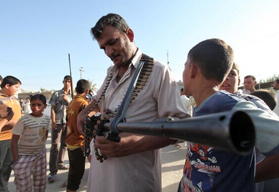 A weapon is checked in the southern Shiite Muslim shrine city of Najaf on Sunday as Iraqis volunteer to fight alongside the security forces against jihadist militants who have taken over several northern cities. [Photo/China Daily]  