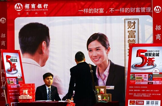 Employees promote wealth management products at a China Merchants Bank Co Ltd branch in Yichang, Hubei province. The Shanghai Interbank Offered Rate has remained low and yields on wealth management products have stayed flat this year. [Photo/China Daily]   