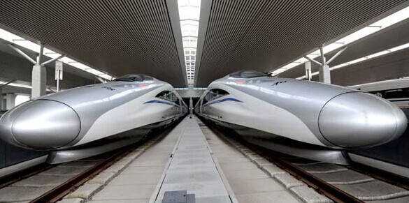 Two high-speed bullet trains sit in Zhengzhou Railway Station in Henan province on Tuesday. [Photo/Xinhua]  
