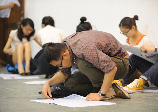 A college graduate looks at a job listing during a job fair on June 7 in Hangzhou, capital of Zhejiang province. The fair was exclusively for 2014 college graduates. HU YUANYONG / FOR CHINA DAILY  