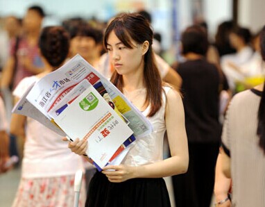 A college graduate looks at a job listing during a job fair on June 7 in Hangzhou, capital of Zhejiang province. The fair was exclusively for 2014 college graduates. HU YUANYONG / FOR CHINA DAILY  