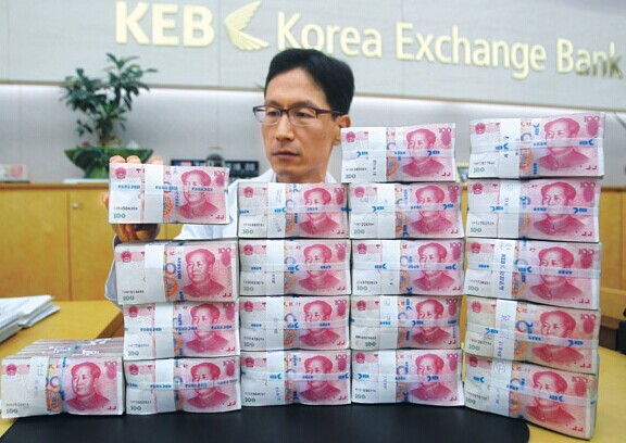 A staff member of the Korea Exchange Bank shows yuan banknotes to reporters during a work process briefing last week. With the rapidly increasing trade exchange between the two countries, China and South Korea plan to directly trade their currencies. [Photo/Xinhua]