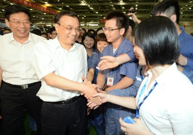 Chinese Premier Li Keqiang (2nd L front) shakes hands with employees while visiting train manufacturer CSR Zhuzhou in central China's Hunan Province, July 4, 2014. Li made a research and inspection tour in Hunan on July 3 - 4. (Xinhua/Ma Zhancheng)