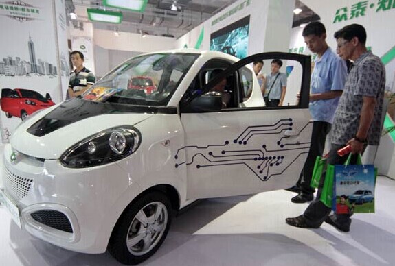 A mini electric car attracts visitors at an international exhibition of new-energy vehicles in Beijing. Both locally produced and imported new energy vehicles will be exempted from a 10 percent purchase tax starting in September in China, in a bid to save energy and reduce emissions. Wu Changqing / For China Daily  