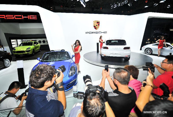 Visitors take pictures of models at the 11th China Changchun International Automobile Expo in Changchun, capital of northeast China's Jilin Province, July 11, 2014. The ten-day expo kicked off here Friday. (Xinhua/Xu Chang)