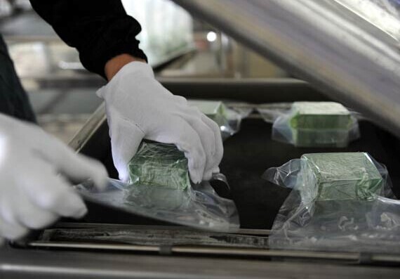 Workers pack neodymium iron boron magnets at a company in Jiangxi province. China accounts for 90 percent of the rare earth supplies in the world.[Photo/Xinhua]  
