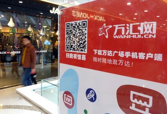 A mobile app poster for Wanhui, a website operated by Dalian Wanda Group Co Ltd, at a shopping plaza in Zhengzhou, Henan province. Wanda has ambitions to build an online-to-offline business empire in China. Provided to China Daily  