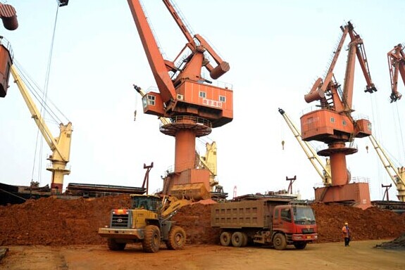 A wheel loader loads a truck with rare earth to be exported next to a row of cranes at the Port of Lianyungang in Jiangsu province. China has announced the second batch of rare earth export quotas for this year, and it has shown no signs of expanding the quotas this year. Provided to China Daily  