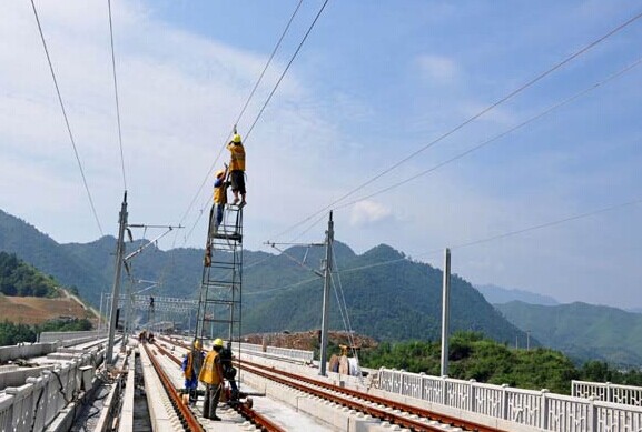 Railway workers maintain power lines along a high-speed rail track in Beijing, In 2013, the country had 103,144 km of track, including 11,028 km for high-speed rail, the longest such network in the world. CHINA DAILY  