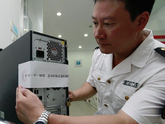 A working staff seals off a computer at Shanghai Husi Food Co., Ltd, a meat supplier for McDonald and KFC, in Shanghai, east China, July 20, 2014. Shanghai food and drug administration has suspended the operation of the food company suspected of supplying stale meat to McDonald and KFC outlets. (Xinhua/Ding Ting)