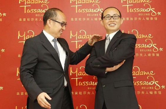 Real estate tycoon Pan Shiyi poses with the waxwork model of himself during an unveiling ceremony at the Madame Tussauds Wax Museum in Beijing, China, April 16, 2014. Madame Tussauds Beijing will open in May. [Photo/Xinhua]