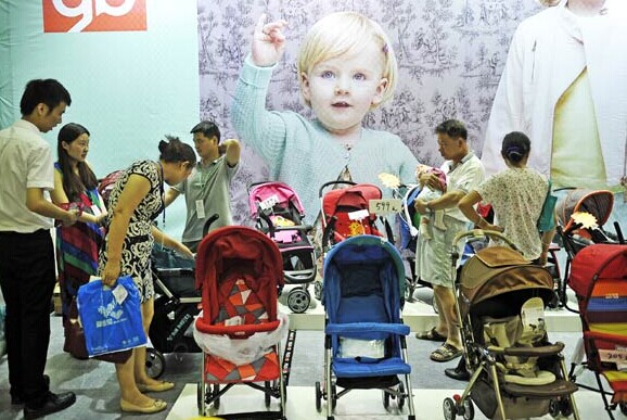 Parents choose strollers at a baby and toddler product expo in Fuzhou, East China's Fujian province, on May 30. CHINA DAILY  