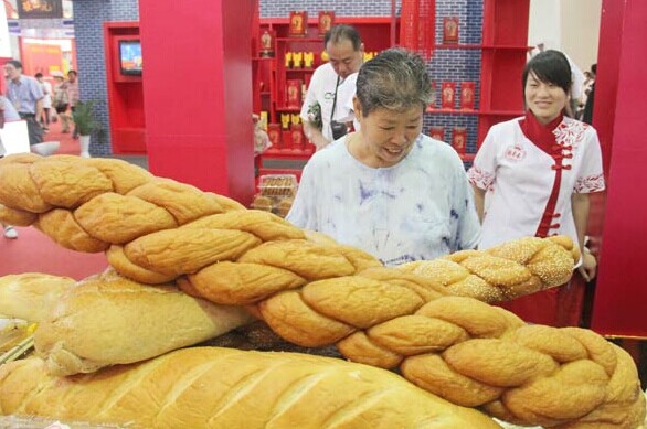 Huge fried dough twists made by Guifaxiang, a time-honored brand from North China's Tianjin municipality, are on display at an expo in Beijing in 2011. HUANG XIAOBING/CHINA DAILY  