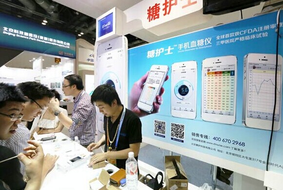 Mobile phones which can measure blood glucose attract attention of visitors at an exhibition in Beijing. LEI KESI/CHINA DAILY  