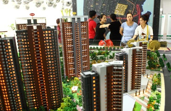 Residents visit new home promotions in Wuhan, capital city of Hubei province. New home prices slid 0.81 percent month-on-month in July, according to a survey of 100 major cities released on Friday by leading property market data provider. [Photo/China Daily]