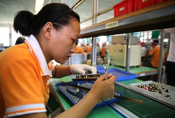 A worker assembles electronic components at a factory in Huaying, Sichuan province. Provided to China Daily  