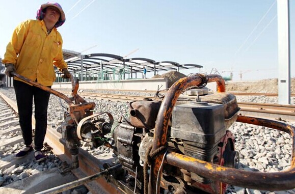 A construction worker bolts together high-speed rail track in Urumqi in the Xinjiang Uygur autonomous region. [Photo/China Daily]  
