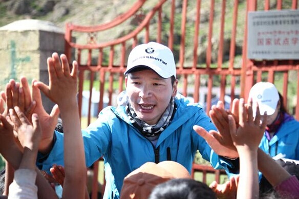 Volunteers waving goodbye to students in the area. [Photo/China Daily]  