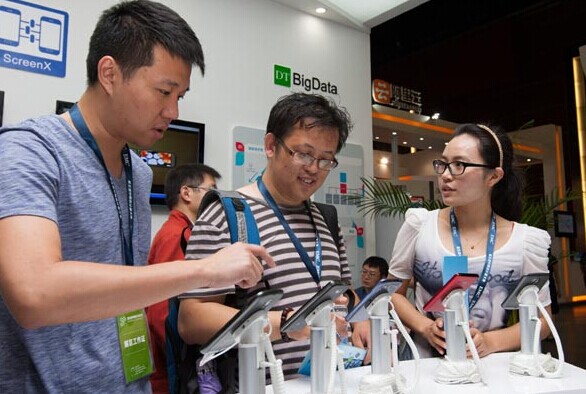 A technician (left) introduces Baidu's cloud service at the 5th China Cloud Computing Conference, which was held in Beijing. Through analyzing the search requests on Baidu Map, a service used on computers and mobile devices, Baidu can help predict traveling trends and assist transportation departments in better managing traffic. [Photo/China Daily]  