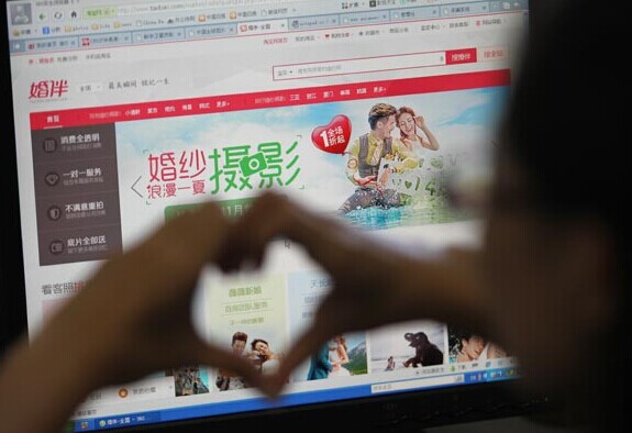 A netizen in Beijing surfs Hunban, a business-to-customer site launched by Hangzhou-based e-commerce group Alibaba. The site aims to connect clients with customized photography services online. [Photo/China Daily]  