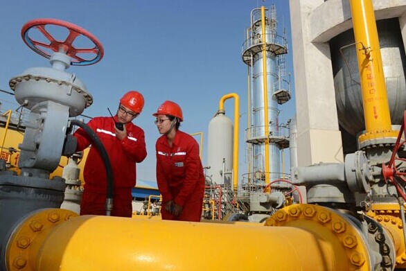 Sinopec workers inspect a natural gas facility in Puyang, Henan province. [Photo/China Daily]  