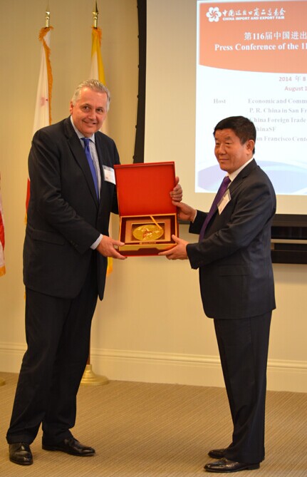Wang Runsheng (right), president of China Foreign Trade Center (CFTC), gives a gift to Dan Herling (left), board chair of San Francisco Center of Economic Development (SFCED), during the press conference which announced the launch of the 116th China Import and Export Fair at the office of San Francisco Chamber of Commerce in San Francisco, California on Aug 15. Lian Zi/China Daily  
