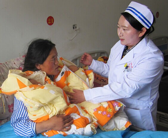 A medical worker at the Dzatod County People's Hospital in Yushu on Aug 6 attends to 23-year-old Gartsok and her newborn twins. [Provided to China Daily]  