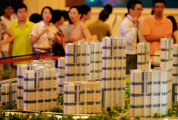 Potential homebuyers examine property models on Saturday in Qingdao, Shandong province. Lending to developers has risen in recent months as the central bank prods financial institutions to reactivate the property market. [Provided to China Daily]  