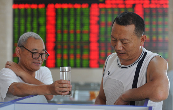 Two investors chat at a securities brokerage in Fuyang, Anhui province, on Aug 21. (Provided to China Daily)