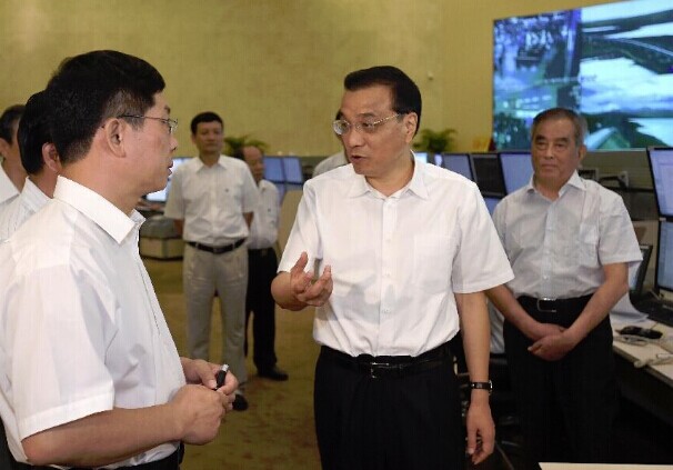 Chinese Premier Li Keqiang (C) talks with staff members at the railway transport command center of the China Railway Corporation (CRC) in Beijing, capital of China, Aug. 22, 2014. Li Keqiang made an inspection tour to the CRC and hosted a symposium at the company on Aug. 22. (Xinhua/Ma Zhancheng)