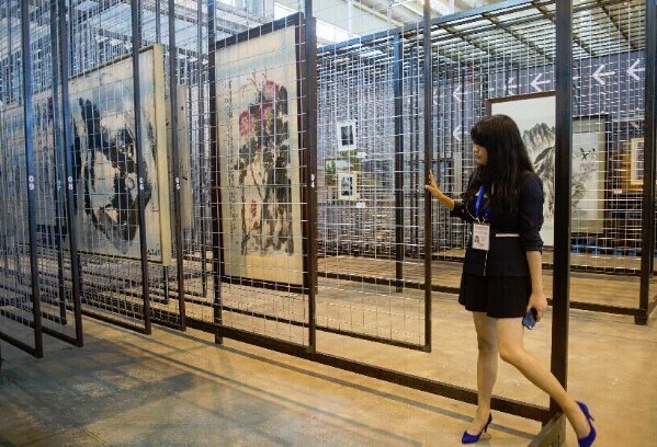 A staff member arranges artworks at the National Base for International Cultural Trade (Beijing) in Beijing, capital of China, Aug. 25, 2014. The National Base for International Cultural Trade opened here on Monday. (Xinhua/Luo Xiaoguang)
