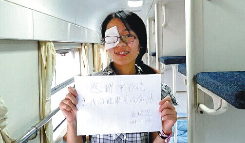 Meng Zhaowen holds a thank-you note she wrote to Sinopec Group after she received her cataract surgery sponsored by the company on Sunday on a train in Yantai, Shandong province. [Photo/China Daily]