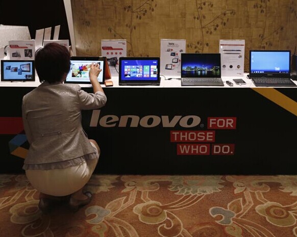 A customer checks out a Lenovo tablet at a shopping center in Hong Kong. Lenovo will spend about $49 million to repair 83,000 IdeaPad laptops sold in the United States. [Photo/China Daily]  