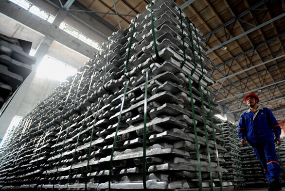 An employee checks stacks of aluminum ingots at a workshop of Aluminum Corp of China in Baise, Guangxi Zhuang autonomous region. [Photo/China Daily]  