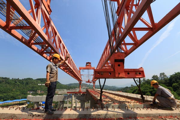 Construction workers complete a bridge project on the Chongqing-Guang'an highway on Thursday. Work on the 79-kilometer roadway is progressing steadily and is expected to be finished by the end of 2016. [Photo/China Daily]