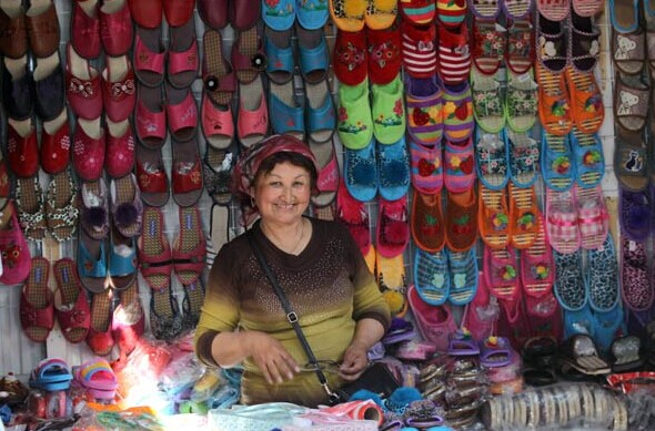 A shopkeeper from Urumqi, Xinjiang Uygur autonomous region, displays her products at a local market in Astana, Kazakhstan. ZOU HONG/CHINA DAILY  