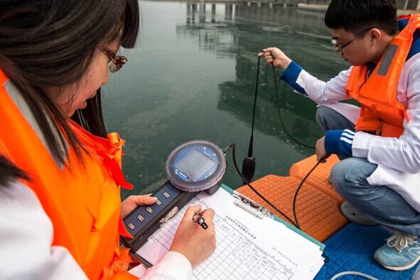 Workers with the South-to-North Water Diversion Project test a water sample from a reservoir in Beijing's Fengtai district. Water quality and the impact of pollution on rivers and lakes are said to be causing growing public concerns.ZHANG YU/XINHUA  