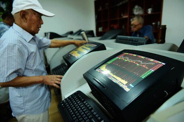 An investor checks share prices at a securities firm's outlet in Qingdao, Shandong province. China's benchmark share index ended flat on Tuesday, following a six-day gaining streak.YU FANGPING/CHINA DAILY  