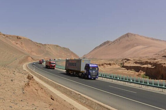 The trucks reach Huoyan Mountain, known as the flaming mountain, in the Tuyugou Grand Valley in Xinjiang. WANG YU/CHINA DAILY  