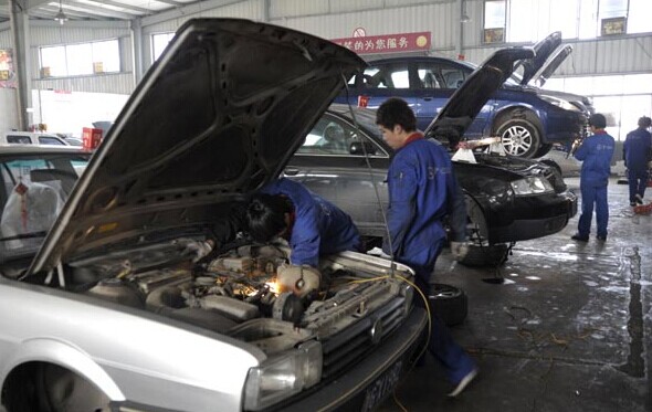Auto maintenance staff work at an auto dealership in Zhejiang province. Analysts said dissatisfaction with showroom and workshop services has resulted in low levels of brand loyalty. [Photo/China Daily]